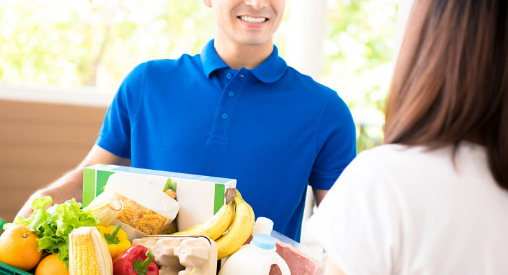 Delivery man delivering food to a woman at home