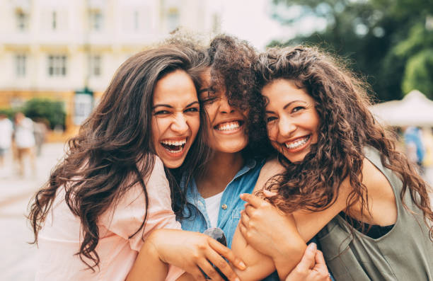 Three best friends hugging each other in the city.