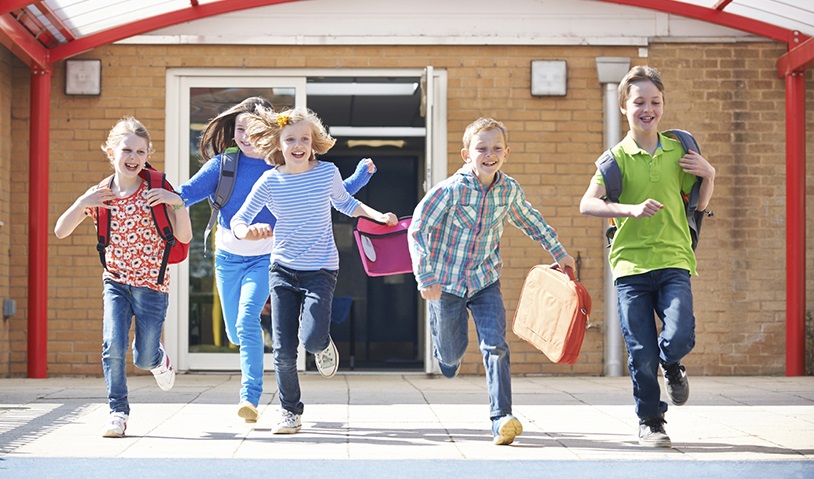 Schoolchildren Running Into Playground At End Of Class