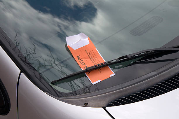 This image is of a car windshield with an orange parking ticket.