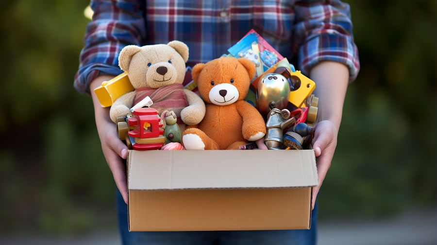 Close-up of a cardboard box in hands full of toys that can be donated. ai generative